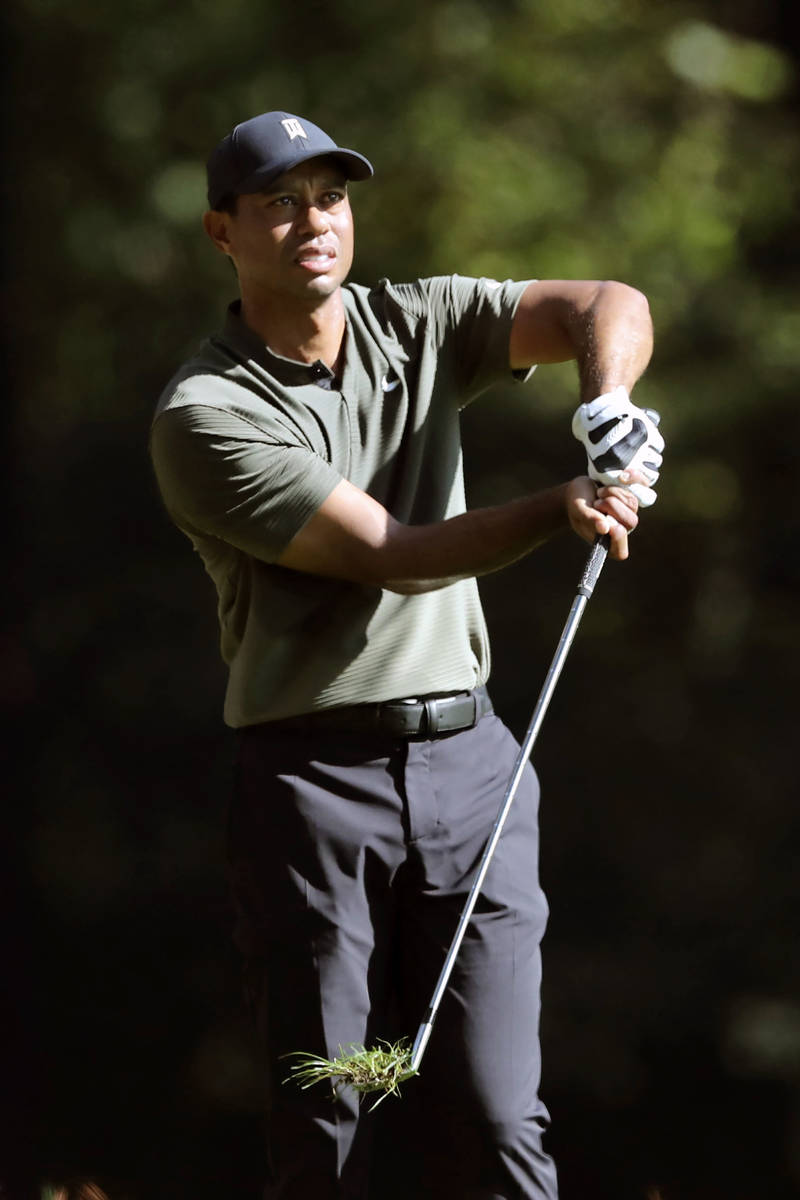 Tiger Woods reacts after teeing off on the 11th hole during the first round of the Masters golf ...