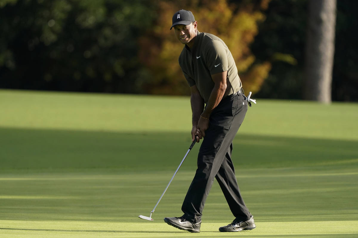 Tiger Woods watches his ball as he misses a birdie putt on the eighth hole during the first rou ...