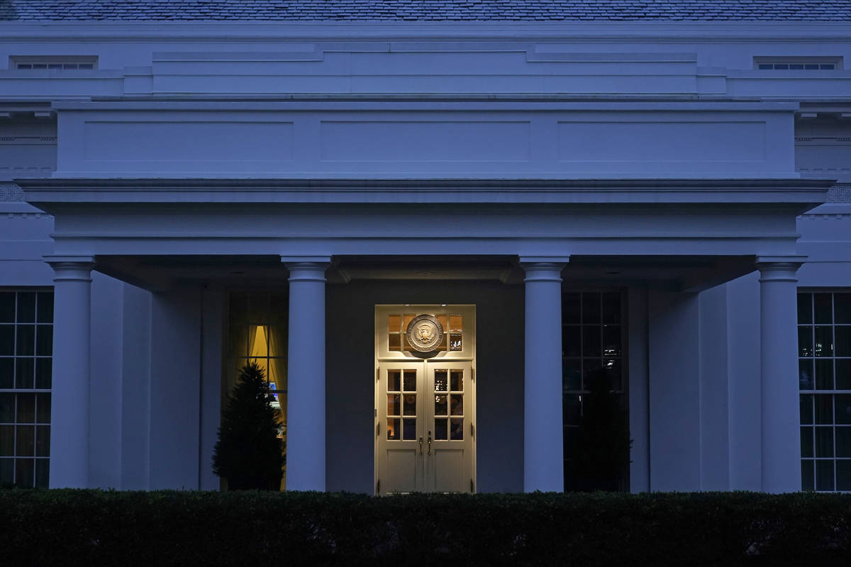 Lights shine on a door leading to the West Wing of the White House at dusk, Wednesday, Nov. 11, ...