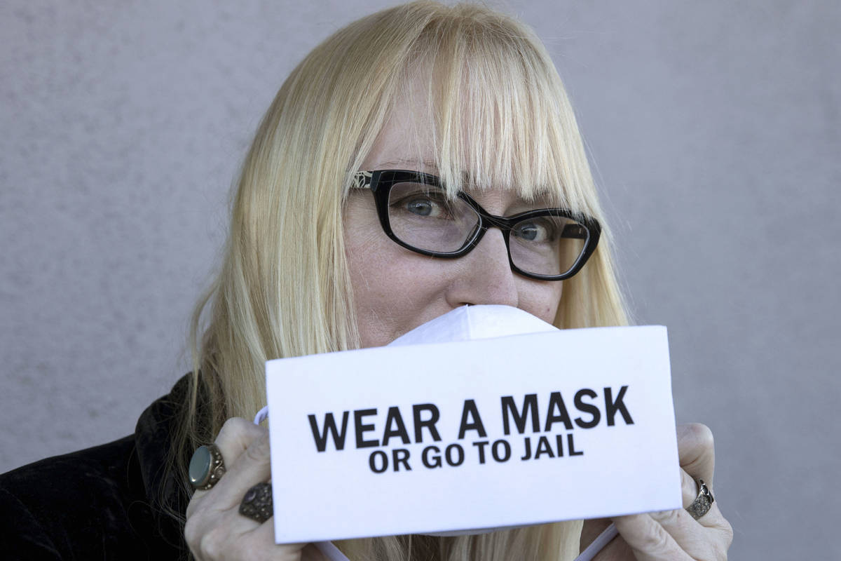 A local fashion designer, Anna Bartoletti, shows off her "Wear a Mask or Go to Jail" ...