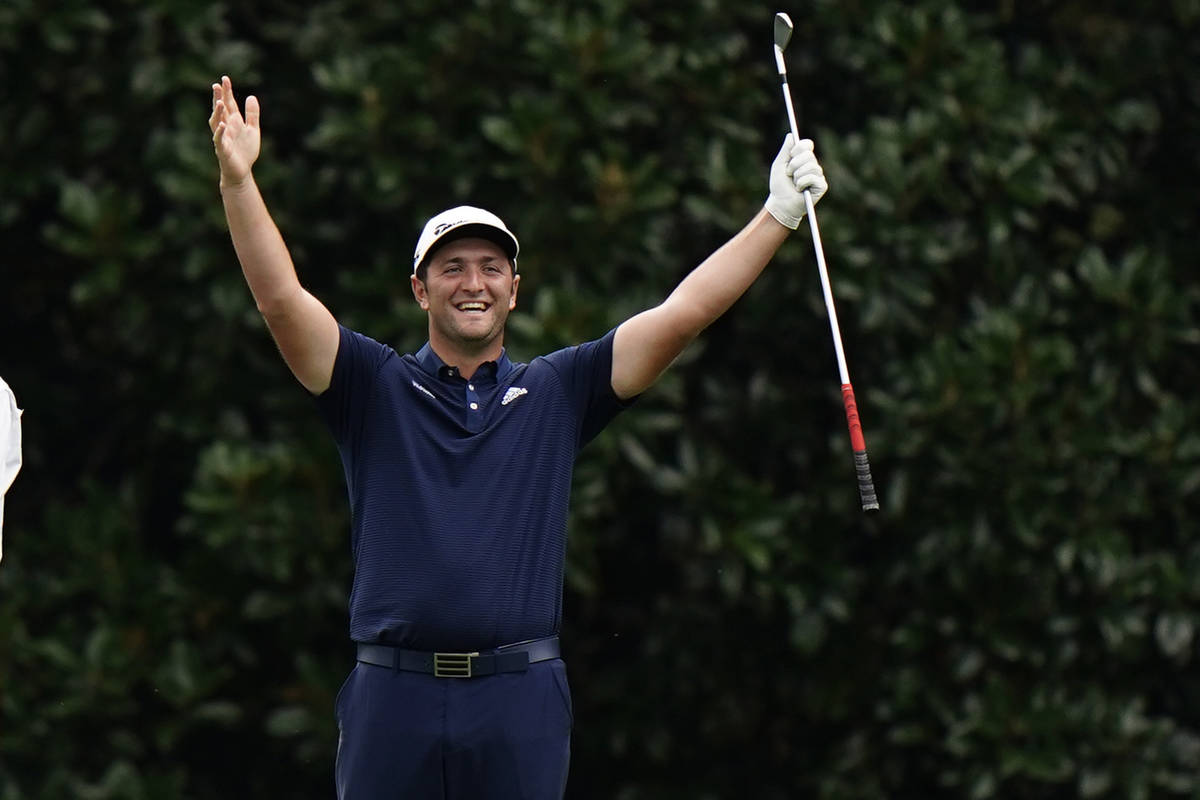 Jon Rahm celebrates after chipping into the hole on the 16th green during a practice round for ...