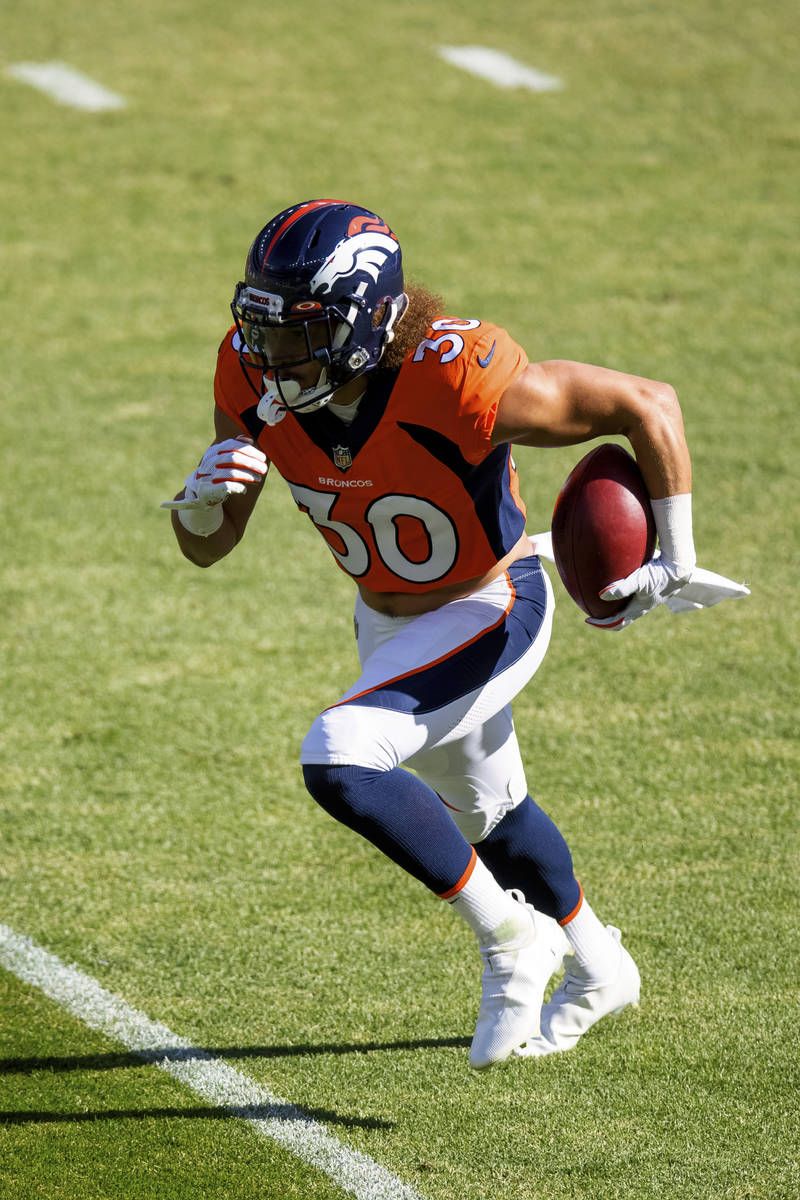 Denver Broncos running back Phillip Lindsay (30) runs with the football while warming up agains ...