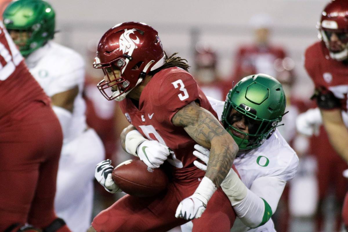 Oregon linebacker Noah Sewell, right, tackles Washington State running back Deon McIntosh durin ...