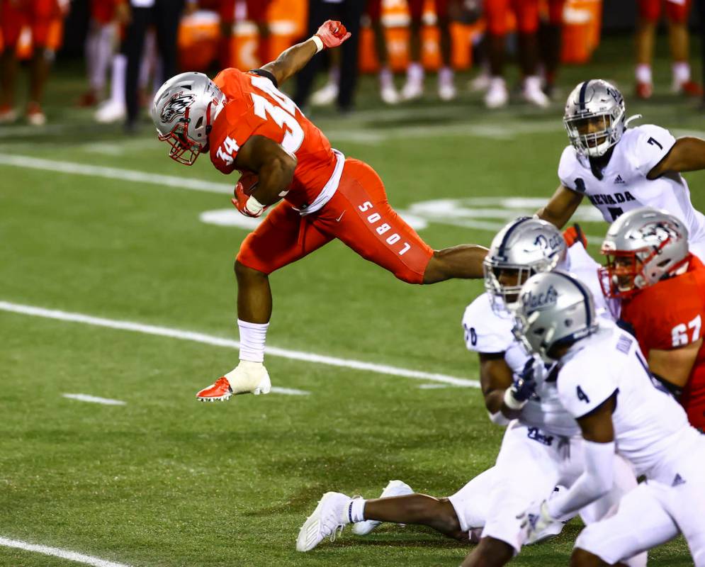 New Mexico Lobos running back Bobby Cole (34) jumps over UNR defenders during the second half o ...