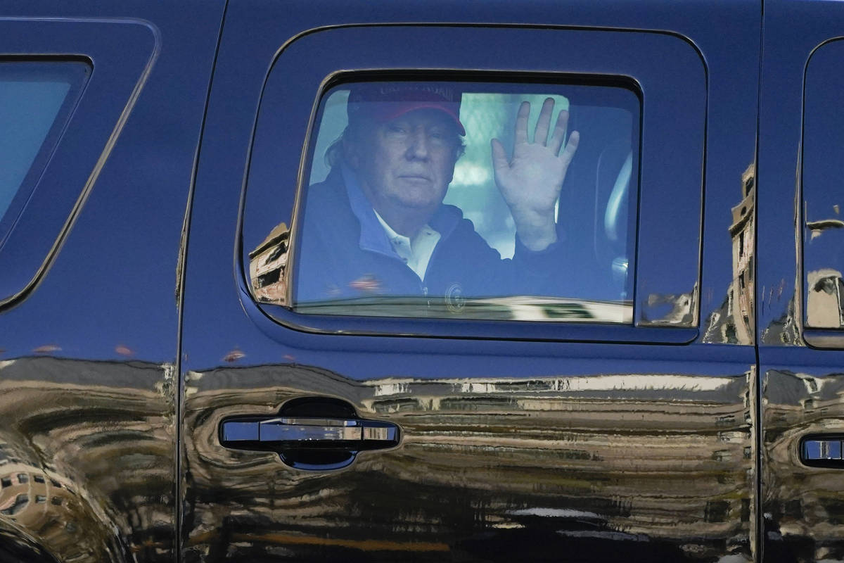 President Donald Trump waves to supporters from his motorcade as people gather for a march Satu ...