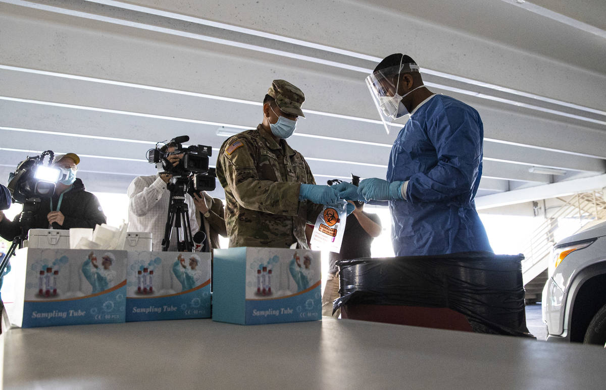 Nevada National Guard specialists Jonathan Macias, left, and Demetrie Barnett store a test tube ...