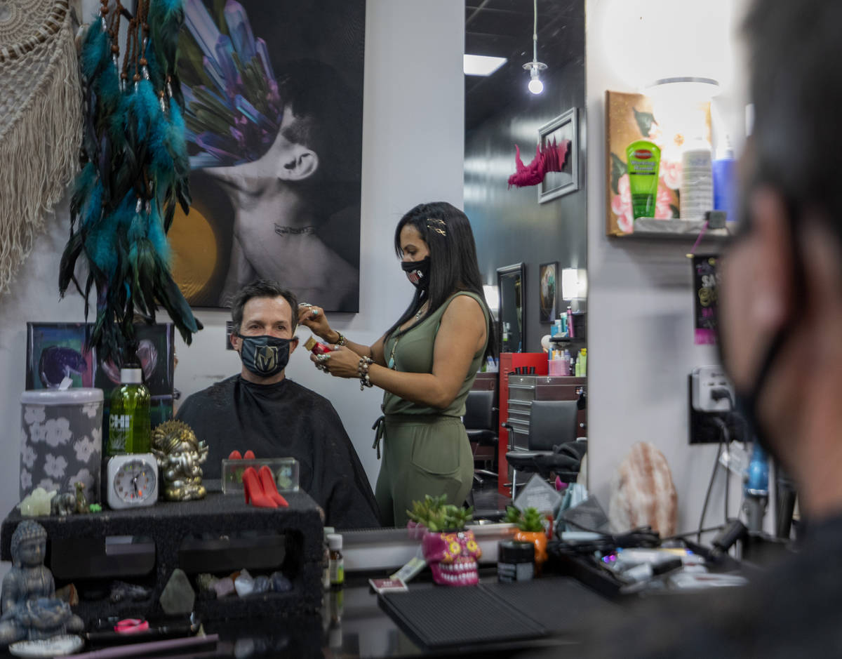 Client Mike Longi, 56, of Las Vegas, receives a hair cut by stylist and creative director of Re ...