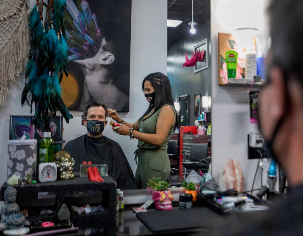 Client Mike Longi, 56, of Las Vegas, receives a hair cut by stylist and creative director of Re ...