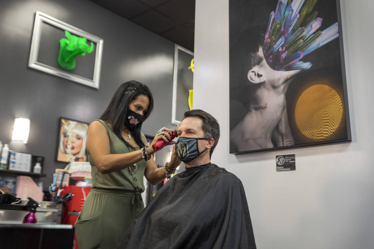 Stylist and creative director of Revolution Salon Lilia Dryer gives a hair cut to Mike Longi, 5 ...