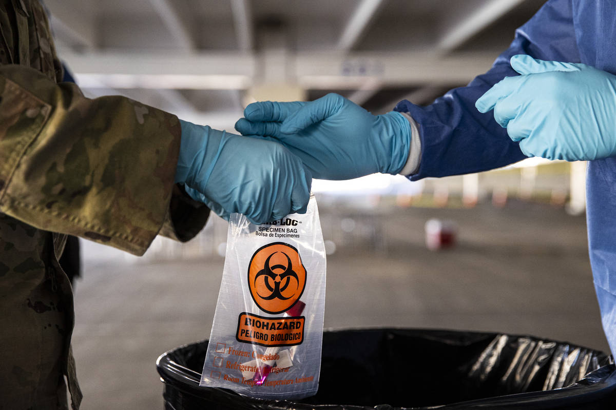 Nevada National Guard specialists Jonathan Macias, left, and Demetrie Barnett store a test tube ...