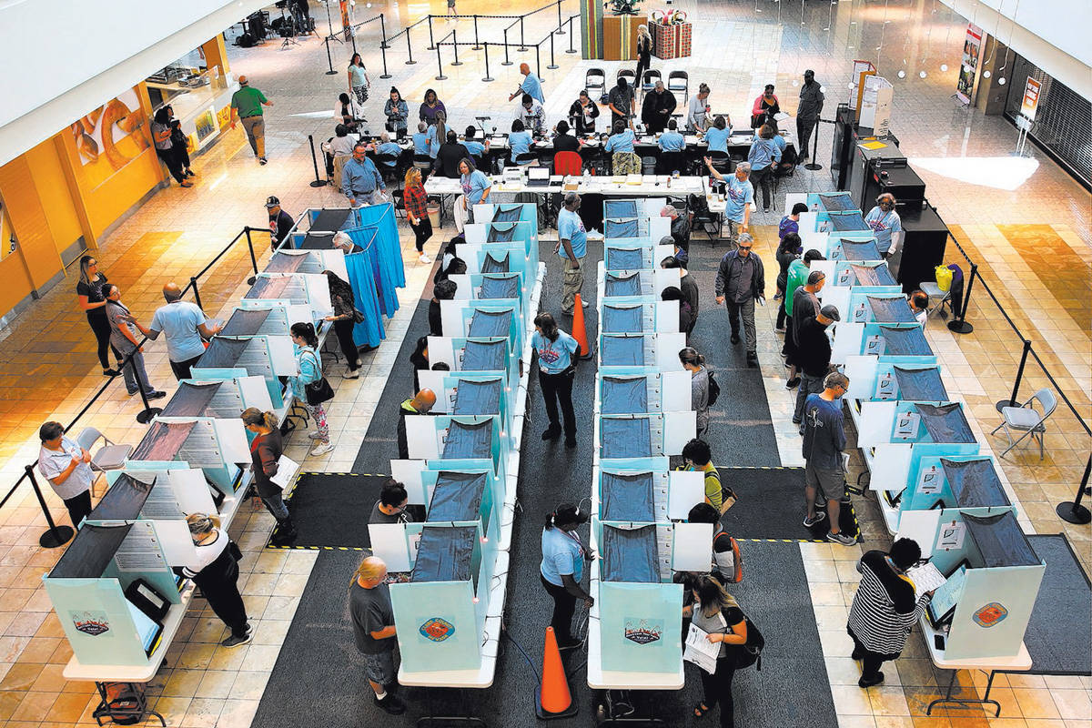 Voters cast their ballots as others sign in at a polling station at Galleria Mall on Tuesday, N ...