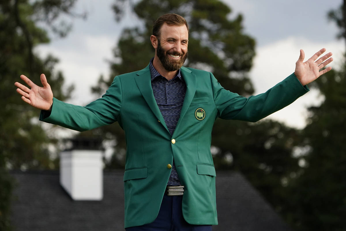 Masters golf champion Dustin Johnson shows off his green jacket after his victory Sunday, Nov. ...