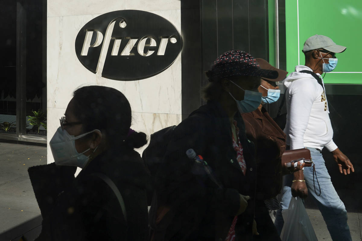 In this Nov. 9, 2020, file photo, pedestrians walk past Pfizer world headquarters in New York. ...