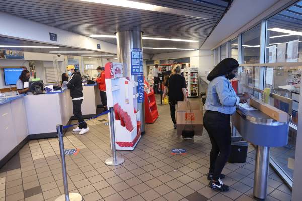 Customers, including Tasha Austin of Henderson, right, ship packages at the main Las Vegas Post ...