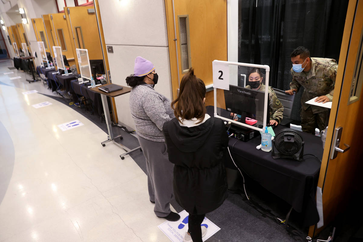 Nevada National Guard specialists Alondra Felix and Daniel Merchant check in Ana Pena, left, an ...