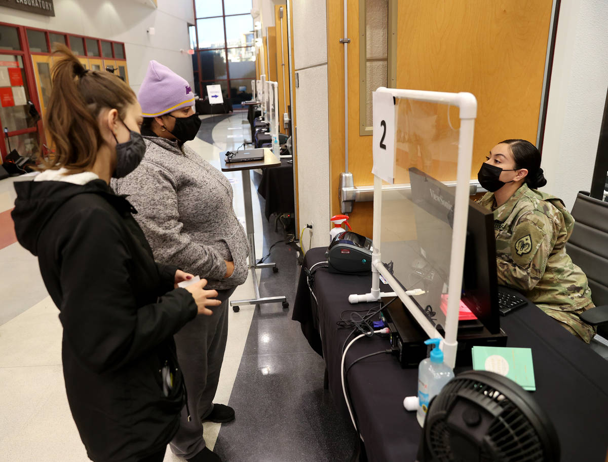 Nevada National Guard Spc. Alondra Felix checks in Ana Pena, left, and Karina Lewis of Las Vega ...