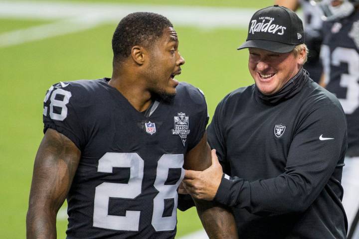 Las Vegas Raiders running back Josh Jacobs (28, left) jokes around with head coach Jon Gruden d ...