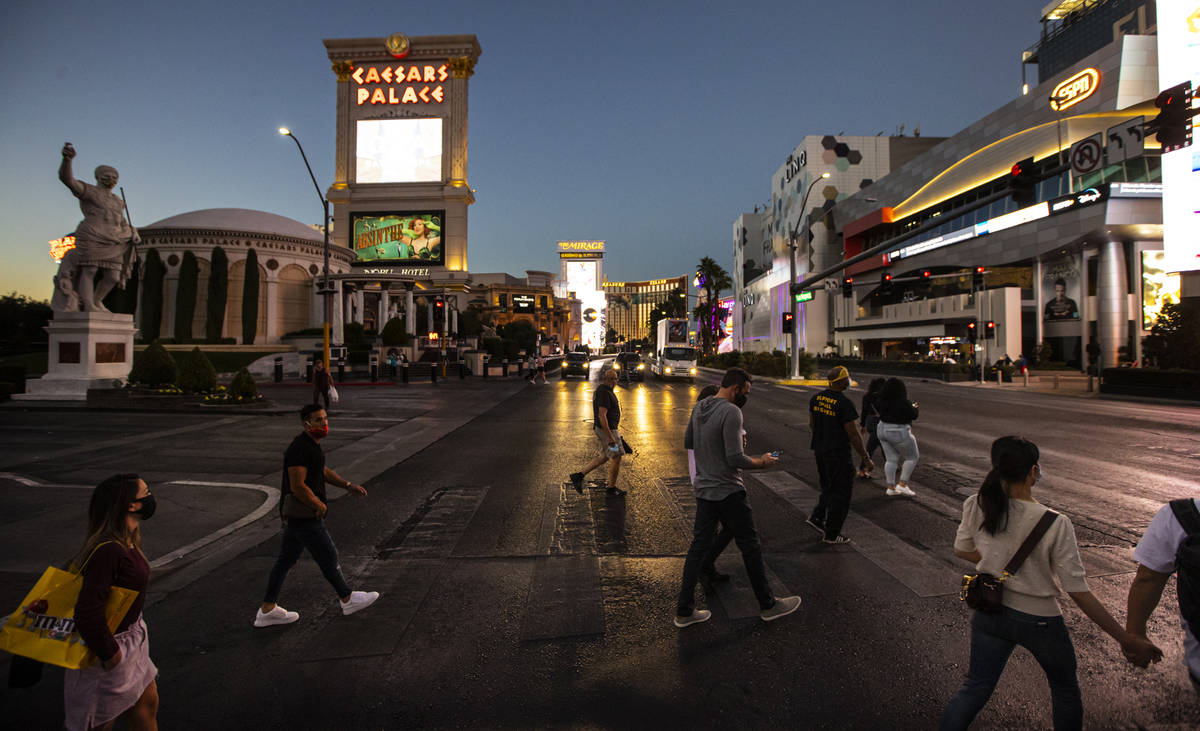 People cross the Las Vegas Strip outside of Caesars Palace and The Linq Hotel Thursday, Nov. 19 ...