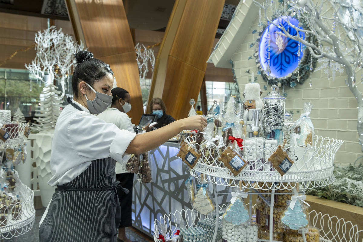 Aria's assistant pastry chef Andrea Madrid arranges treats in the retail area during the unveil ...