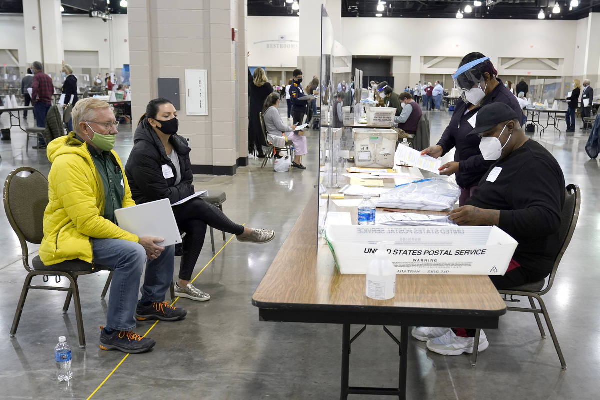 Election workers, right, verify ballots as recount observers, left, watch during a Milwaukee ha ...