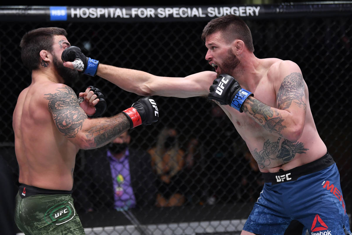 (R-L) Tim Means punches Mike Perry in their welterweight bout during the UFC 255 event at UFC A ...