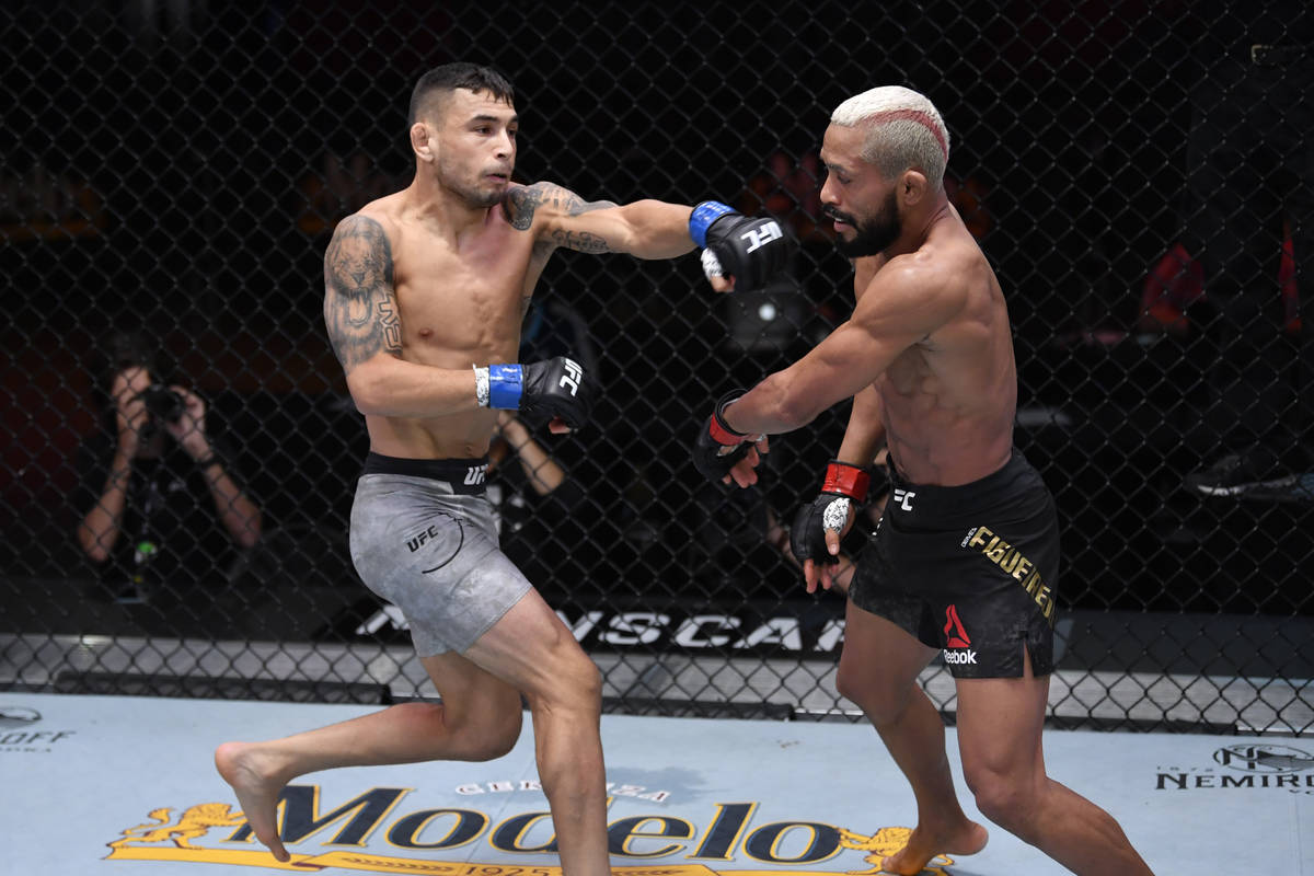 (L-R) Alex Perez punches Deiveson Figueiredo of Brazil in their flyweight championship bout dur ...