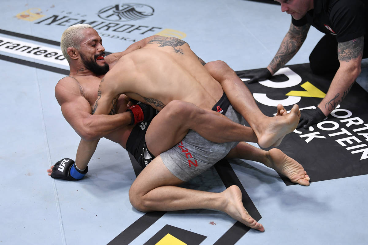 (L-R) Deiveson Figueiredo of Brazil submits Alex Perez in their flyweight championship bout dur ...