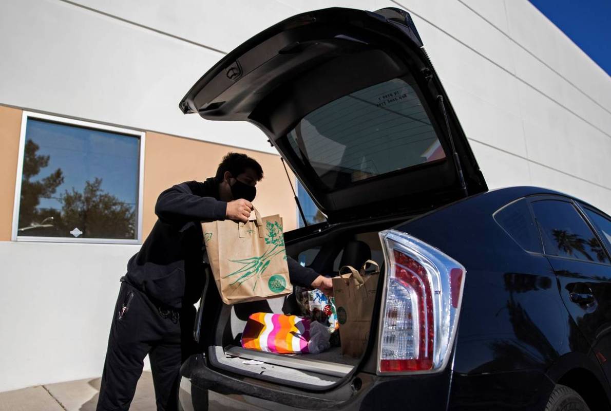 Tristan Sanchez delivers bags of donated food to a vehicle during a food drive hosted by Nectar ...
