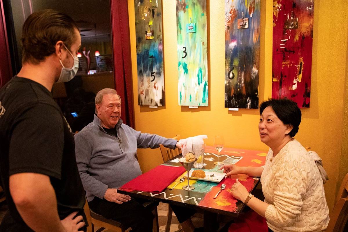 Dakota Watkins, from left, talks to customers Jay Yager, left, and his wife Lucy Yager, right, ...