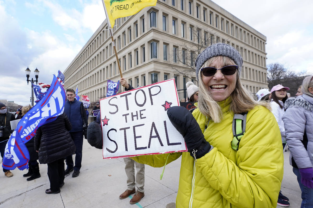 Alyss Kovach holds a sign outside the Richard H. Austin state office building during a rally in ...