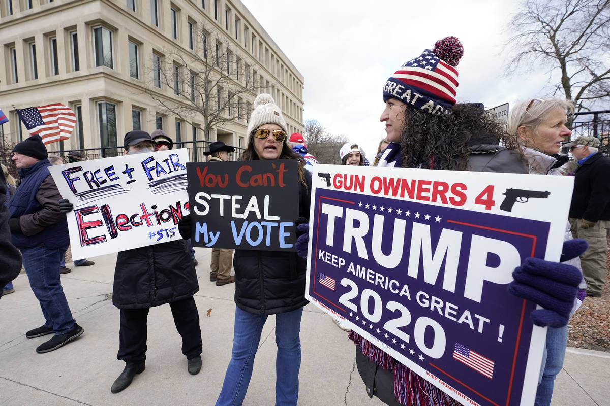 Protesters hold signs outside the Richard H. Austin state office building during a rally in Lan ...