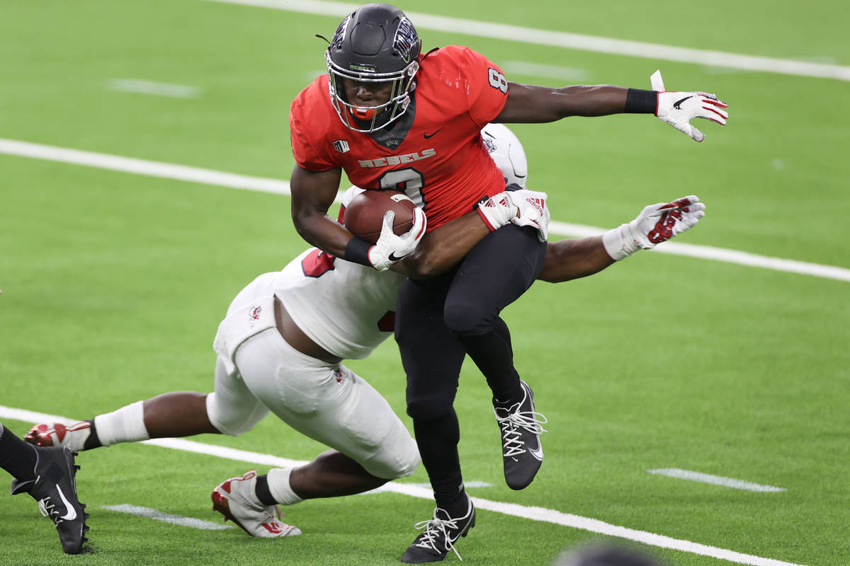 UNLV Rebels running back Charles Williams (8) is tackled by Fresno State Bulldogs linebacker Ma ...