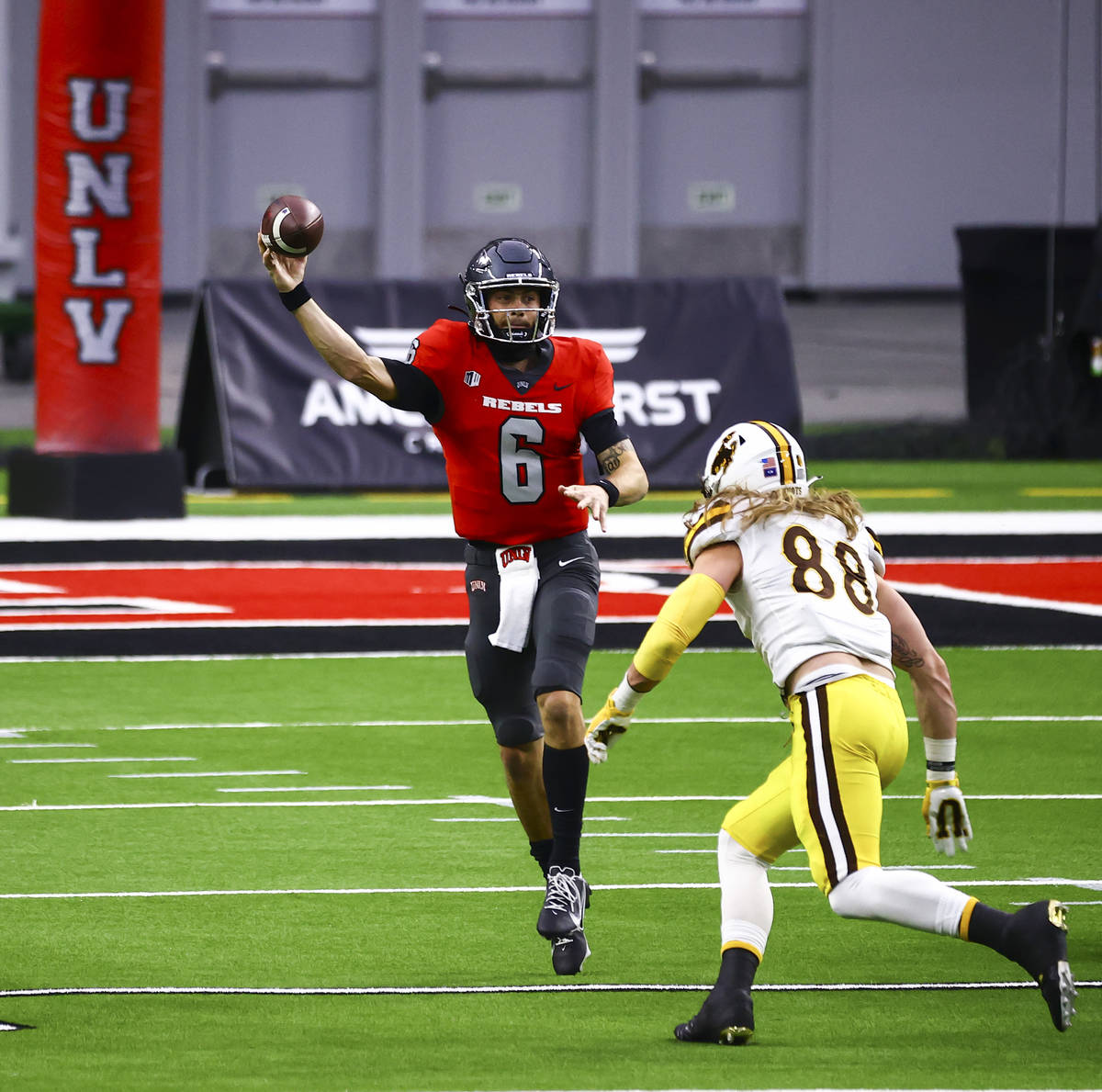UNLV Rebels quarterback Max Gilliam (6) looks to throw under pressure from Wyoming Cowboys defe ...
