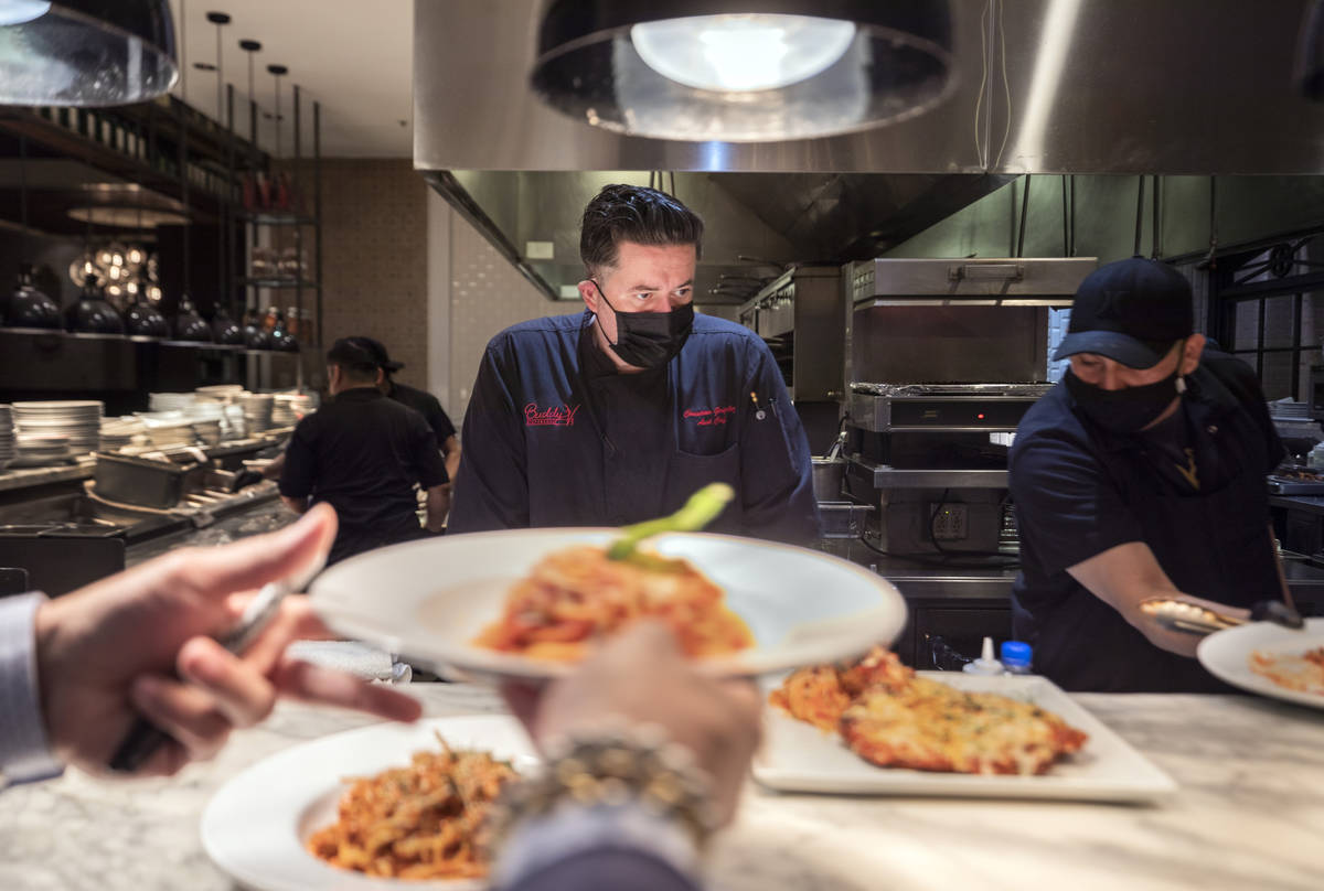 Executive sous chef Christian Gonzalez, center, oversees dishes going out to be served at Buddy ...