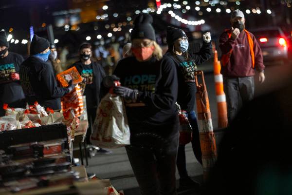Volunteers ready holiday food items to give out at Hope for the City's drive-through food pantr ...
