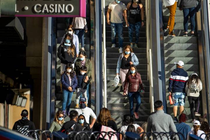 A crowd moves about outside of The Cromwell from a pedestrian bridge along the Las Vegas Strip ...