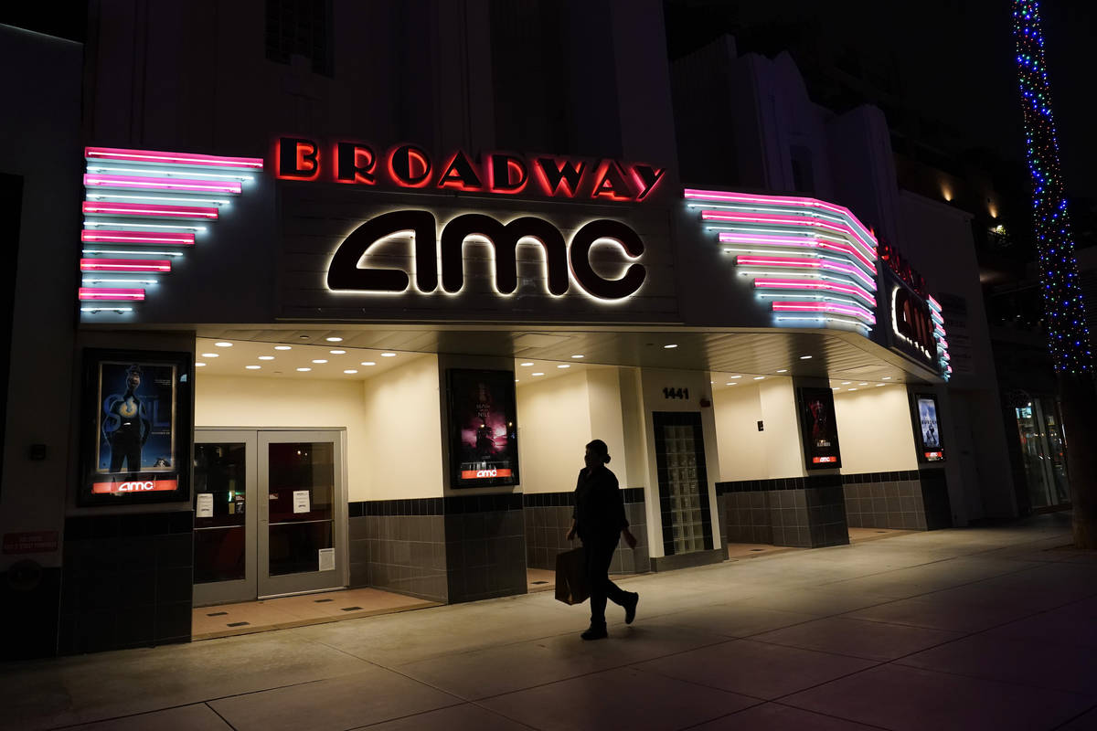 In this Thursday, Nov. 19, 2020, file photo, a shopper walks past a closed AMC movie theater in ...