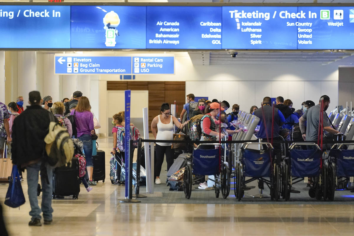 Holiday travelers check in at kiosks near an airline counter at Orlando International Airport T ...