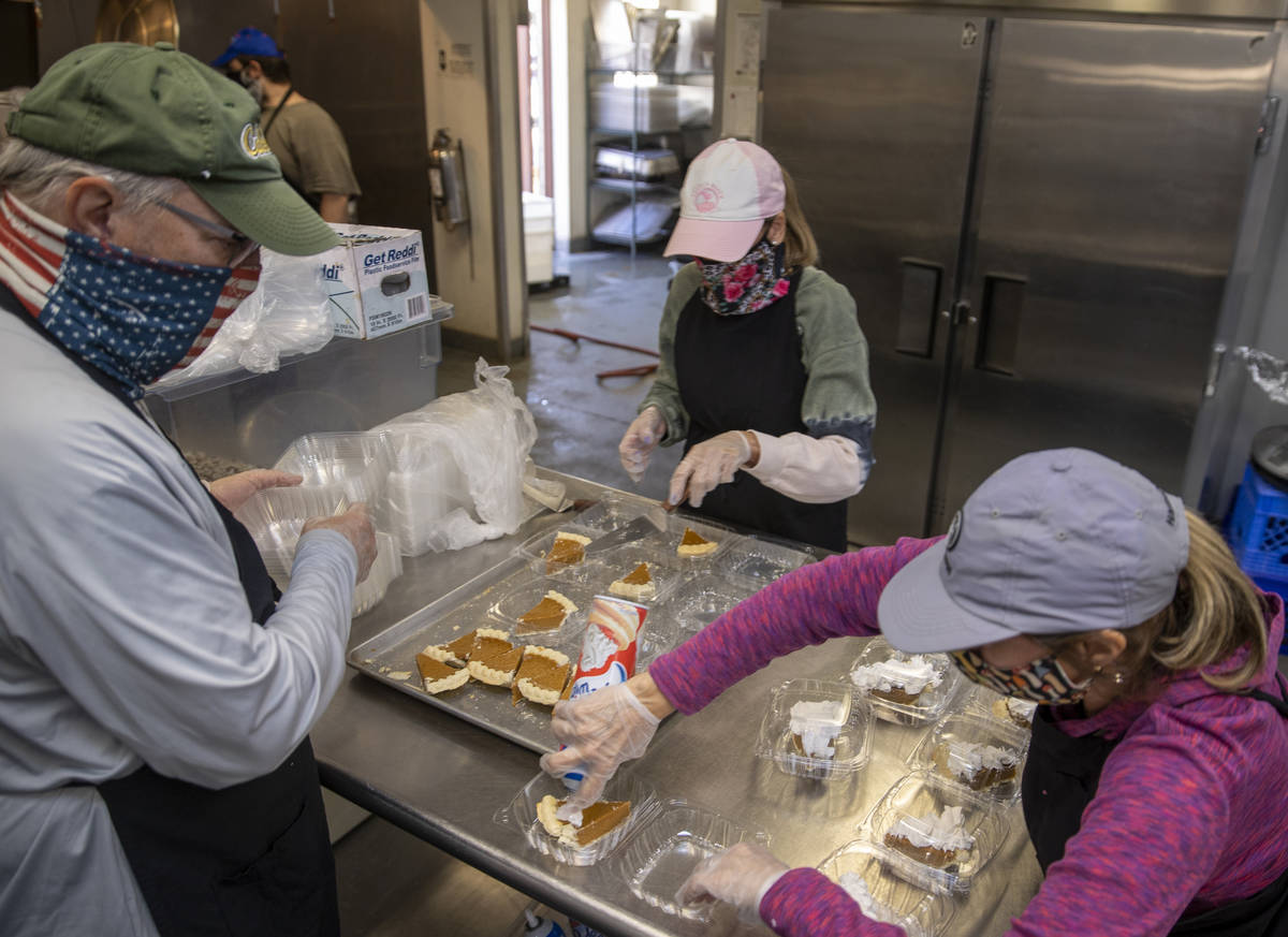 Volunteers serve up pie as part of a Thanksgiving meal at the Las Vegas Rescue Mission with foo ...