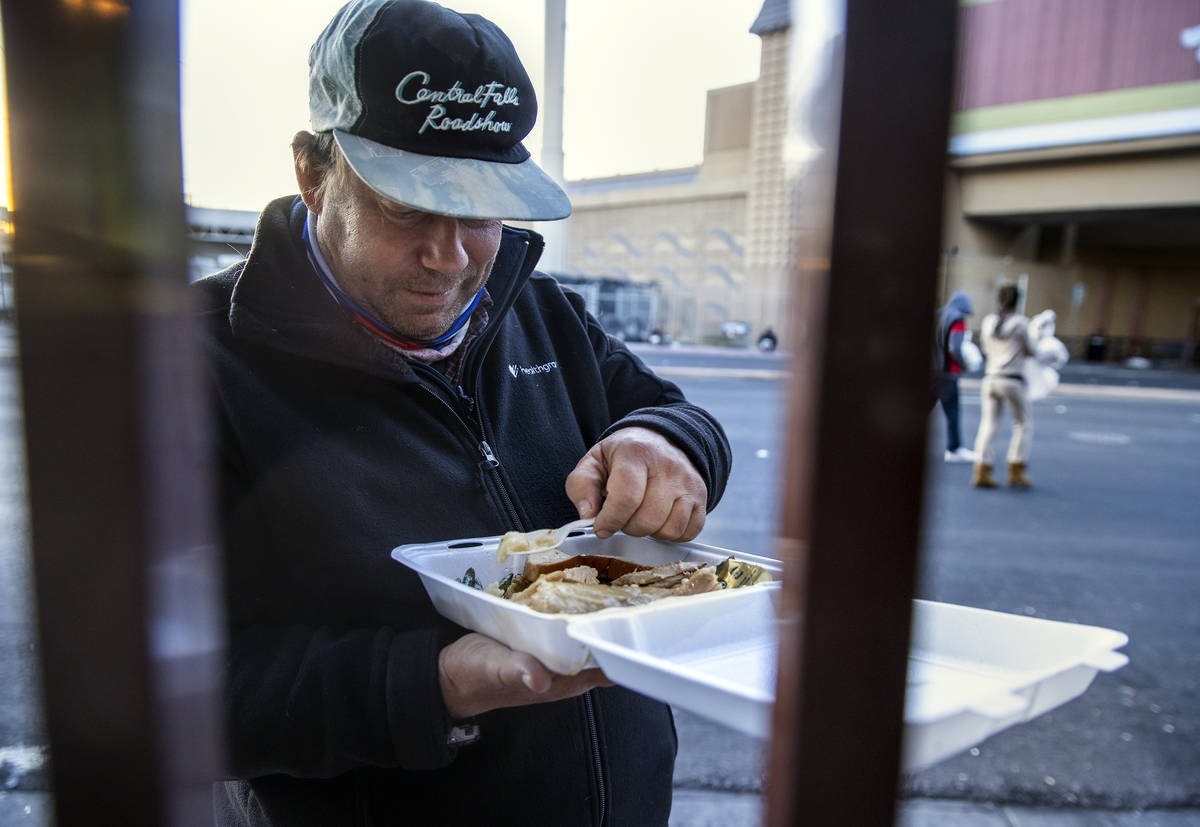 Phil Harnischfeger enjoys a prepared Thanksgiving meal outside the Las Vegas Rescue Mission wit ...