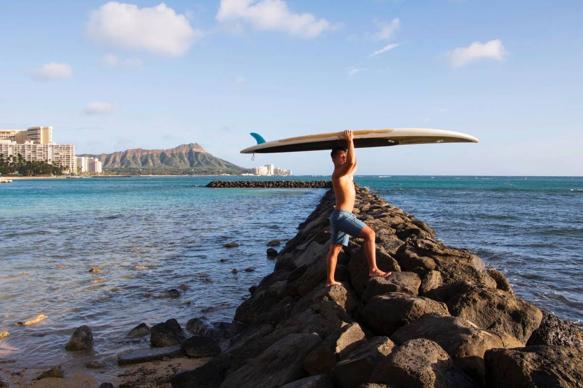 Bryant de Venecia poses for a photo with his paddleboard in Honolulu, Wednesday, Nov. 11, 2020. ...