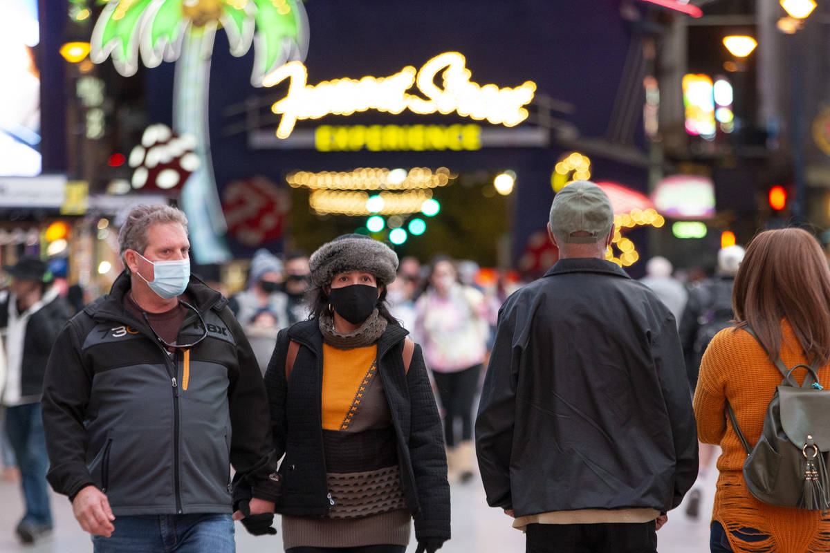 Visitors to Fremont Street Experience dress for cool temperatures on Thursday, Nov. 26, 2020, i ...