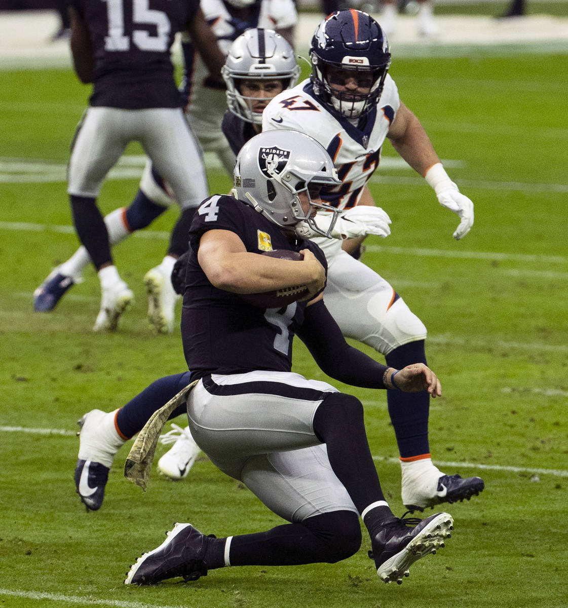 Las Vegas Raiders quarterback Derek Carr (4) slides as Denver Broncos inside linebacker Josey J ...