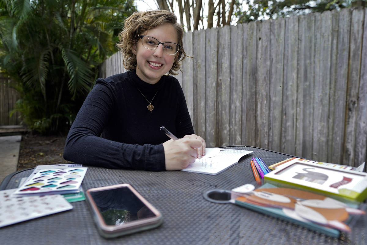 Kara McKlemurry poses for a photo while writing Thanksgiving notes to family and friends at her ...