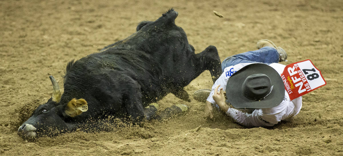 J.D. Struxness of Milan, Minn., mistimes the leap and eats some dirt in Steer Wrestling during ...