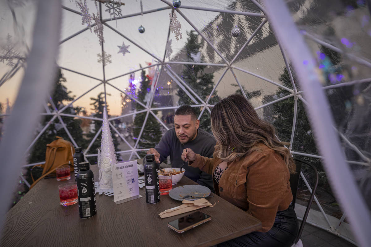 Gabriel Chairez, 40, left, and Angelica Gonzalez, 40, of Las Vegas, eat in an igloo during the ...