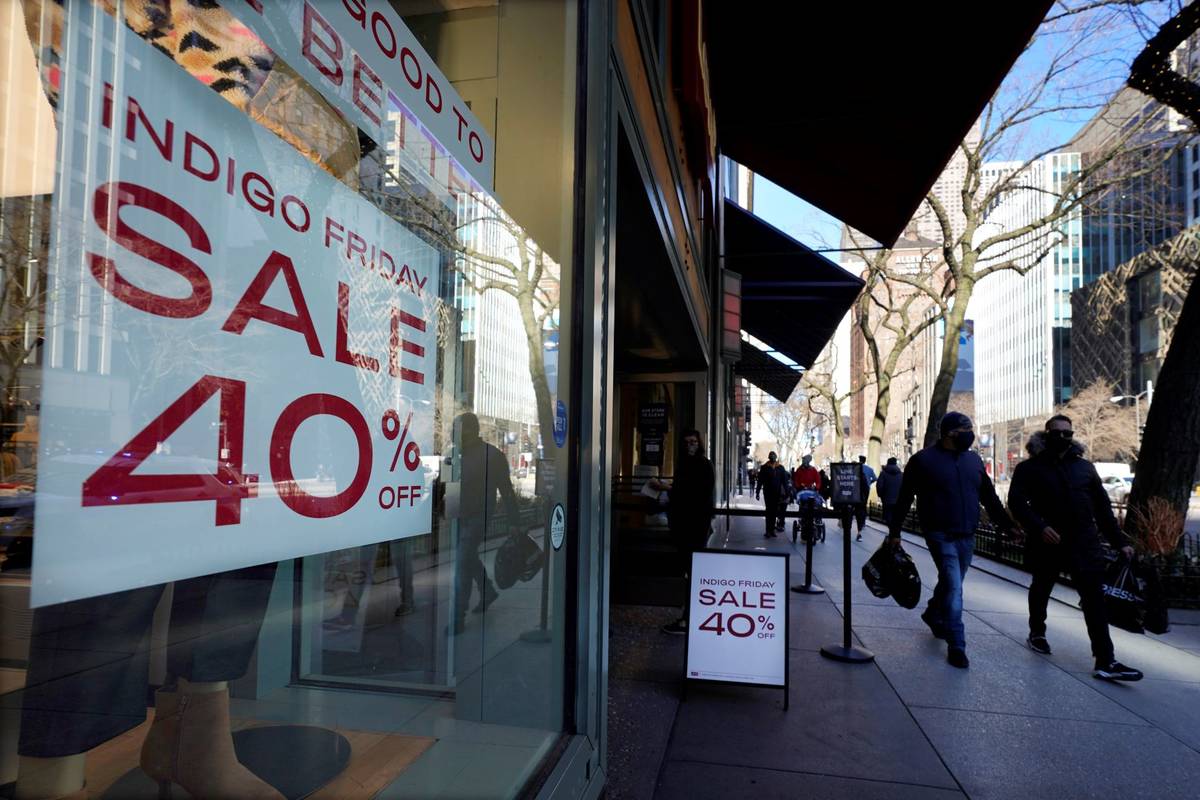 Shoppers pass an Indigo Friday 40% Off sign Saturday, Nov. 28, 2020, on Chicago's famed Magnifi ...