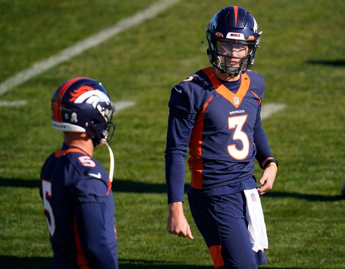 Denver Broncos quarterback Drew Lock, right, confers with quarterback Riley Neal during NFL foo ...