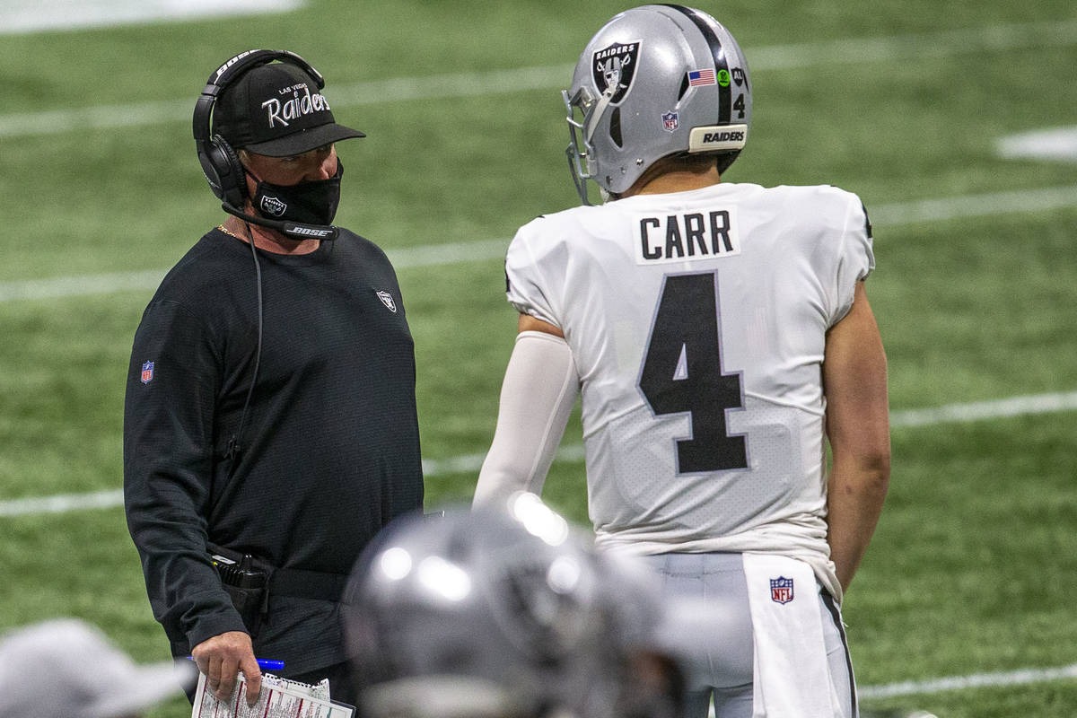Las Vegas Raiders head coach Jon Gruden and quarterback Derek Carr (4) have a conversation duri ...