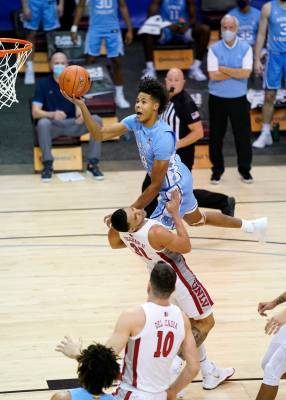 North Carolina guard Puff Johnson (14) leaps over UNLV guard Marvin Coleman (31) to shoot for t ...